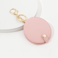Pink PU leather round mirror keychain with golden clasp on a white display base - Pink