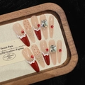 Detail of luxury press-on nails featuring red stars, white pearls and sparkling rhinestones - XS