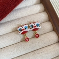 Dettaglio orecchini leone rosso con ciondoli a moneta su espositore in velluto - Perno in argento 925 / Stile Ciondolo Testa di Leone con Moneta di Rame
