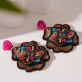 Detalle macro de pendientes de flores bordados a mano con cuentas de colores y cristal - Pendientes colgantes de flores de colores (Pin de plata)