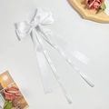 Elegant white satin hair bow with long streamers for women on a decorative tray - Pure White