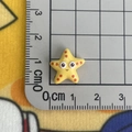 Mini yellow resin starfish charm with cartoon face showing 1.5cm size on a grid mat - 07*Yellow Starfish Mini