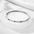 Close-up of silver steel bangle with blue round zircon stones and a hinged clasp - 4mm / Silver-Blue Zirconia