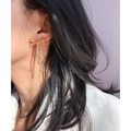 Eleganti orecchini a fiocco dorati con nappe di strass indossati da una modella - Oro