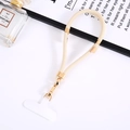 Close-up of beige woven nylon phone lanyard with gold metal buckle and T-shaped plastic tab - Off-white