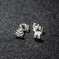 Macro detail of asymmetric Christmas stud earrings featuring a silver reindeer and Xmas tree - Xmas Tree Reindeer / Steel