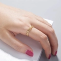 Detail eines eleganten Gold-Infinity-Rings mit Zirkonia, getragen am Model-Finger - Gold Gedrehte Unendlichkeit