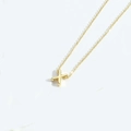 Minimalist gold necklace featuring a small polished letter X pendant on a fine chain - Letter X