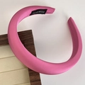 Detail of pink satin wide headband with handmade label on a dark wood frame - Rose Red