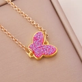 Close-up of golden necklace featuring a pink glittery butterfly pendant on beige leather - Pink