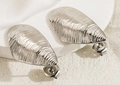 Macro detail of silver drop earrings with irregular horizontal shell-like textures - Steel Color Conch