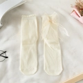 Close-up of cream-white calf socks with delicate lace trim and large sheer tulle bow detail - One Size / Milk White