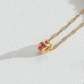 Elegante collana dorata con un ciondolo circolare incastonato con pietre rosso rubino - Rosa Rosso