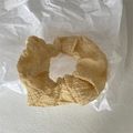 Detail eines gelben Haargummis mit Blasenstruktur auf weißem Papierhintergrund - Gelb