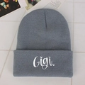 Gray knitted beanie hat for winter featuring a GIGI embroidered logo in a flat lay view - Gray