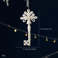 Vintage cream-white key Christmas ornament with gold glitter hung on a snowy pine branch - Key White Gold Pendant
