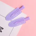 Dettaglio di due fermagli per capelli viola opachi con scritta Grape su sfondo rosa - Lettera Grape Viola
