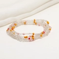 Detailed view of colorful layered seed bead waist chains on soft white fabric background - 80cm / Transparent/Orange Pink Red Accents