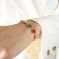 Gouden armband met kleurrijke rechthoekige strasstenen gedragen om een vrouwenpols - Gouden Armband-15+5cm