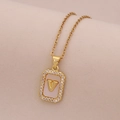 Gros plan d'un collier en or 18 carats avec pendentif en nacre et lettre V sertie de zircons - Lettre V
