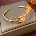 Close-up of gold-plated star bracelet with cubic zirconia on a gray jewelry box - Gold