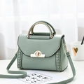 Fashionable green PU leather handbag with woven details and golden metal hardware on a desk - Green