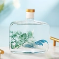 Square glass diffuser bottle with green dried flowers and golden cap on marble tray - Bluebell