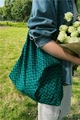Outdoor shot of a green geometric print tote bag with wide strap and floral accent - Black With Green And Blue Chain Pattern