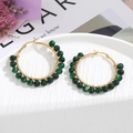 Boho gouden oorringen met groene natuurstenen gepresenteerd op een wit display plateau - Donkergroene Patroon Kralen