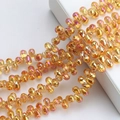 Macro detail of amber iridescent teardrop glass beads for DIY jewelry making and crafts - 100 Pcs/Pack / Gold Rose Red
