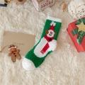 Close-up of green and white snowman plush Christmas socks with festive gift packaging - Snowman with Hat