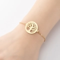 Primer plano de una pulsera dorada de árbol de la vida lucida en la muñeca con elegancia - Dorado
