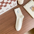 White cotton crew socks featuring blue heart embroidery on a wooden table setting - One Size / White