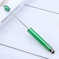 Green metallic beaded stylus pen for touchscreens with matte finish on wood surface - Coffee