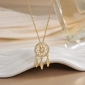 Zirconia dreamcatcher necklace with three gold feathers on a ceramic display - Gold Hollow Mandala
