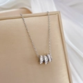 Macro shot of silver titanium steel necklace with three pavé diamond-set ring pendants - Titanium Steel / Silver