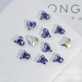 Macro shot of 11 heart-shaped K9 crystals in purple and champagne on a white base - Crooked Heart 8x9mm