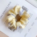 Floral print mesh scrunchie in yellow and purple tie-dye colors on a magazine background - Phantom Yellow