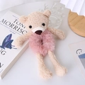 Detail view of a cute beige plush bear hair tie with soft pink velvet band on wooden desk - Pink