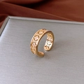 Vista macro de anillo de flor bañado en oro con circonitas en soporte gris - Anillo Abierto de Flor Calada (Chapado en Oro Real) / Dorado