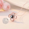 Detail of rose gold clover necklace with black stone showing 100 languages projection - Rose Gold Clover
