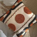 Bohemian cushion cover with orange tufted dots and tassels on knit blanket - Double Lines