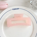 Matte pink hollow rectangular shark hair claw clip displayed on a ceramic plate - 10.5cm / Pink