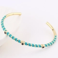 Detail of gold-plated bangle with turquoise enamel and black stone dots decoration - Lake Blue