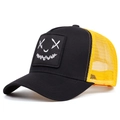 Close-up of the square smile patch and yellow mesh texture on the street trucker cap - Adjustable / Black Yellow