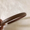 Close-up detail of vintage brown litchi pattern leather headband with fine grain texture - Coffee