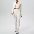 Close-up of three-piece cream yoga set featuring zip jacket with thumbholes and leggings - S / Light Ivory