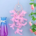Detail of pink dream catcher featuring soft feathers and colorful beads on blue wall - Standard Type / Pink