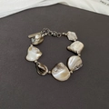 Detalle de pulsera de cadena con nácar natural blanco y pequeñas cuentas metálicas - Pulsera Plateada Con Concha Blanca
