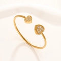 Bracciale rigido regolabile in acciaio dorato con doppi cuori simmetrici e zirconi bianchi - 27 Oro